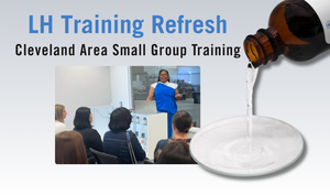 Promotional graphic for 'LH Training Refresh' featuring the text 'Cleveland Area Small Group Training' above a small inset photo of a presenter speaking to a class, alongside a brown bottle pouring liquid into a white dish on a light gray background.